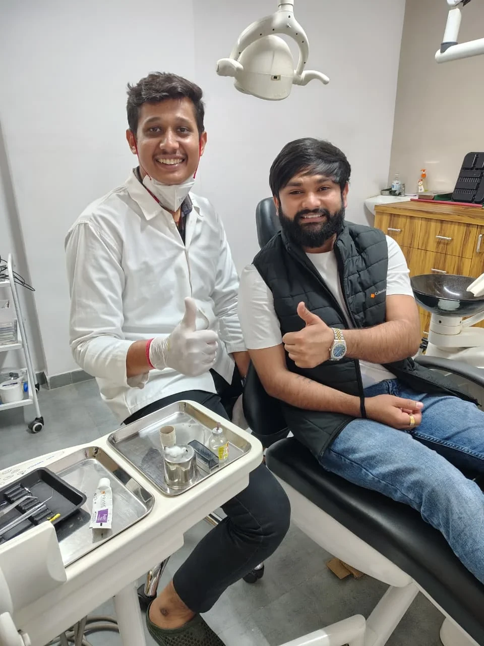 A patient seated beside a member of the dental team in the clinic.